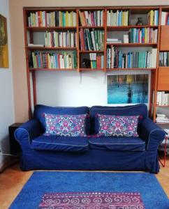 un sofá azul en una sala de estar con estanterías en Piccola Torre Moltrasio, en Moltrasio