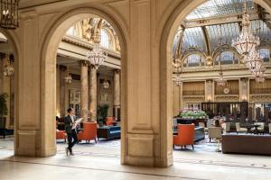 um homem a andar pela entrada de um edifício em Palace Hotel, a Luxury Collection Hotel, San Francisco em São Francisco