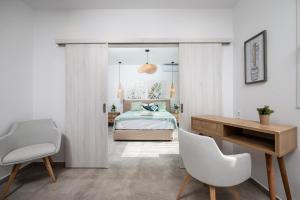 1 dormitorio con 1 cama, escritorio y sillas en Thalassa Beach House, en Kefalos