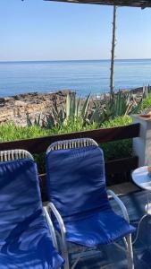 twee blauwe stoelen op een patio met uitzicht op de oceaan bij Sunset Villa - Torre Pozzillo in Carini