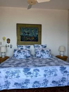 een slaapkamer met een blauw en wit bed met kussens bij Sunset Villa - Torre Pozzillo in Carini