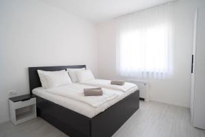 1 dormitorio blanco con 1 cama grande con sábanas blancas en Villa Domino, en Mostar