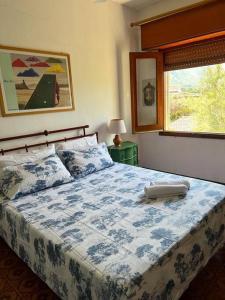 een slaapkamer met een blauw en wit bed en een raam bij Sunset Villa - Torre Pozzillo in Carini