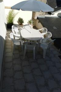 ベレームにあるGite Les Promenadesのパティオ(白いテーブル、椅子、パラソル付)