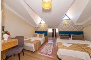 a bedroom with two beds and a desk and a table at Ista Palace Hotel in Istanbul