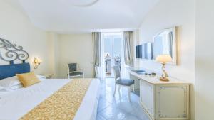 a hotel room with a bed and a desk at Hotel Nettuno in Ischia