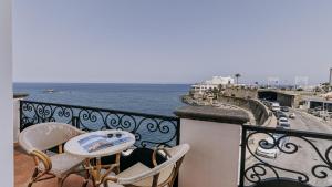 a balcony with a table and chairs and the ocean at Hotel Nettuno in Ischia +37 photos