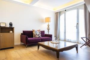 a living room with a purple couch and a coffee table at Hôtel Des Gouverneurs in Bastia
