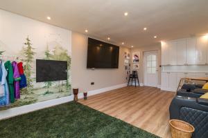 sala de estar con sofá y TV de pantalla plana en Scenic, Getaway Lux House in Countryside Village, en Beccles