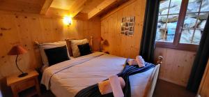 - une chambre avec un lit dans une cabane en rondins dans l'établissement Chalet Chez Cheryl, Mayens-de-Chamoson, à Ovronnaz