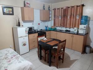 a small kitchen with a table and a refrigerator at Budget Studio Apartment - with Fast Wifi and Netflix in Nairobi