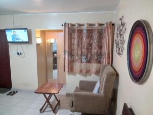 a living room with a chair and a table at Budget Studio Apartment - with Fast Wifi and Netflix in Nairobi