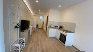 a kitchen with white cabinets and a counter top at Night & Flight Airport Apartman in Vecsés