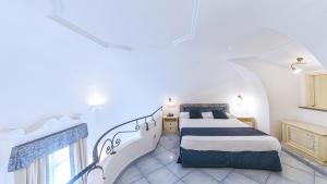 a white bedroom with a bed and a staircase at Hotel Nettuno in Ischia