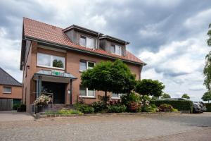 a brick house with flowers in front of it at Hotel am Tiergarten in Raesfeld
