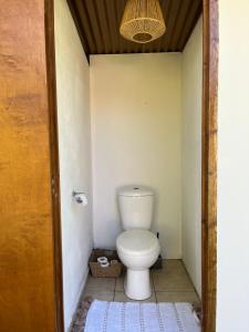 a bathroom with a toilet in a small room at O'coco Bungalow in Paea