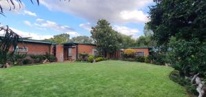 a house with a large lawn in front of it at Emani Guest House in Mokopane