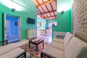 ein Wohnzimmer mit einem Sofa und einer grünen Wand in der Unterkunft Antica Dimora del Platano - R3832 in Nurachi