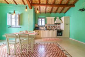 eine Küche mit grünen Wänden sowie einem Tisch und Stühlen in der Unterkunft Antica Dimora del Platano - R3832 in Nurachi