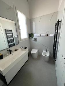 a white bathroom with a sink and a toilet at Martanna Rooms in Carini +15 photos