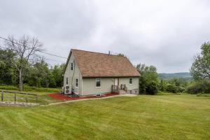 a small white house with a large yard at Mountainview (Secluded Retreat) in Canandaigua