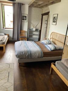 a bedroom with a large bed and a chair at le Châtelet in La Chaux Neuve