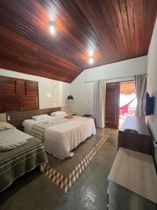 a bedroom with two beds and a wooden ceiling at Bangalôs da Barra Chalé 3 in Barra Grande