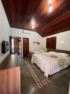 a bedroom with two beds and a wooden ceiling at Bangalôs da Barra Chalé 3 in Barra Grande