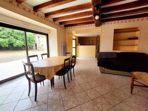 - une salle à manger avec une table, des chaises et un lit dans l'établissement Dépaysement à la campagne, à Saint-Martin-de-Sanzay