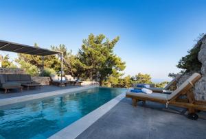 une piscine avec des chaises longues et une villa dans l'établissement Villa K-Villa with private pool, à Ierápetra