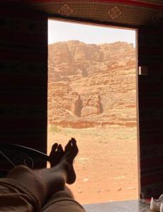 Une personne pieds sur une fenêtre donnant sur le désert dans l'établissement Moon city camp, à Wadi Rum