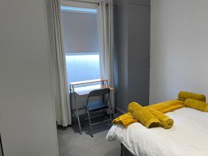 a bedroom with a bed with a yellow blanket on it at Seaside House-NEW DAY PROPERTIES in South Shields