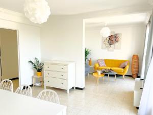 a living room with a yellow couch and a chair at La Cigale du Port in Cassis