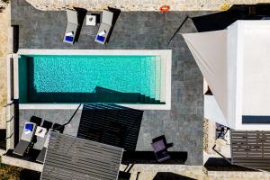 an overhead view of a swimming pool with chairs and tables at Villa K-Villa with private pool in Ierápetra