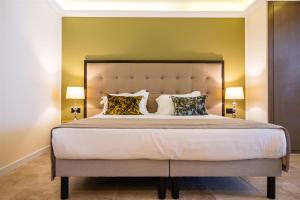 a bedroom with a large bed with two lamps at Hôtel Des Gouverneurs in Bastia