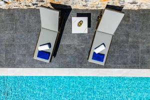 an overhead view of a swimming pool with two white and blue tables at Villa K-Villa with private pool in Ierápetra
