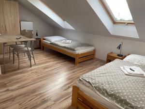 a attic room with two beds and a table at Różana 51 in Opole