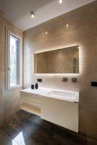 a bathroom with a white sink and a mirror at Casa Duccio alle Mura della Città in Siena