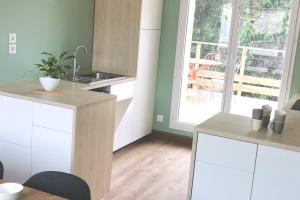a kitchen with white cabinets and a sink and a window at Maison - Louviers centre - proche golf in Louviers