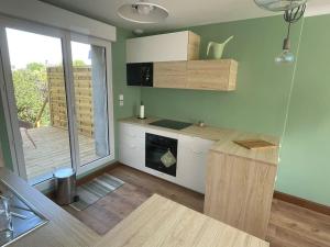 a kitchen with white cabinets and a large window at Maison - Louviers centre - proche golf in Louviers