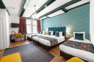 a hotel room with three beds and a chandelier at Hotel des Arts in Amsterdam