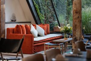 an orange couch in a room with a large window at Hôtel Saint Nicolas in La Rochelle