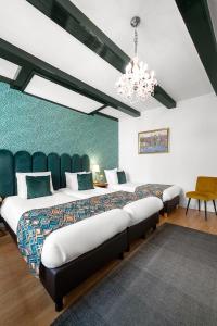 a bedroom with a large bed and a chandelier at Hotel des Arts in Amsterdam