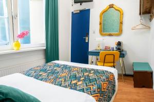 a bedroom with a bed and a table and a mirror at Hotel des Arts in Amsterdam