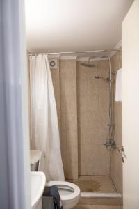 a bathroom with a shower with a toilet and a sink at Minimal loft at Kastellokampos in Patra