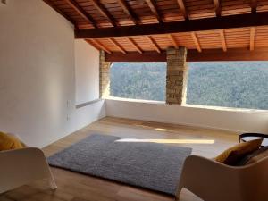 uma sala de estar com uma grande janela e um tapete em house in the medieval village em Apricale