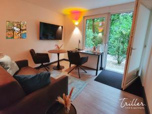ein Wohnzimmer mit einem Sofa und einem Tisch in der Unterkunft Stay by Triller - Aparthotel & Pool in Saarbrücken