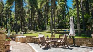 a patio with a table and chairs and an umbrella at Sani Cape Shared Pool Villas in Sani Beach