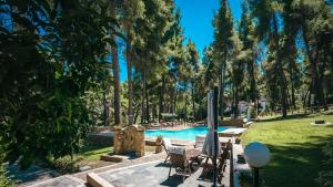 サニビーチにあるSani Cape Shared Pool Villasの椅子と木々が並ぶ公園内のプール