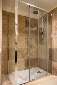 a shower with a glass door in a bathroom at Hôtel Des Gouverneurs in Bastia